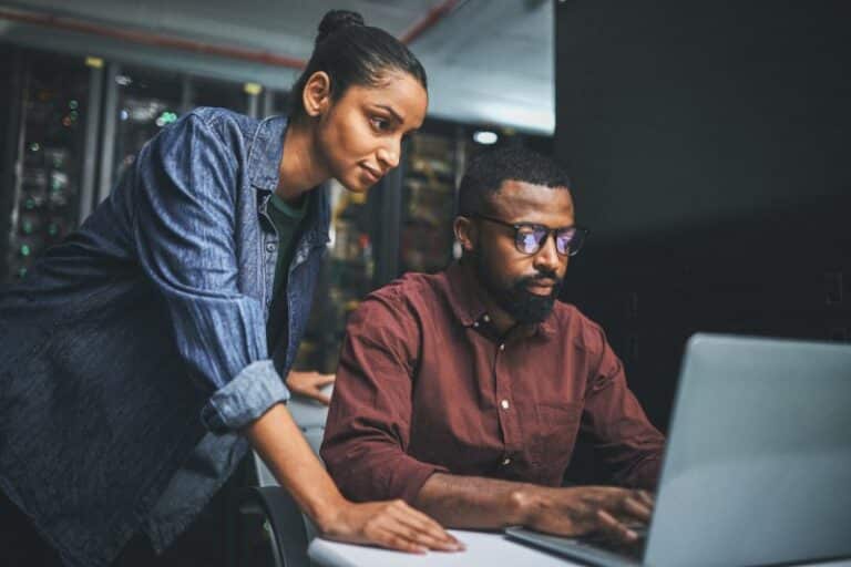 two co-workers looking at a computer together